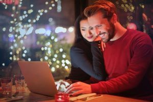 Couple happily working on their finances because they've each discovered how to communicate with your spouse about money.