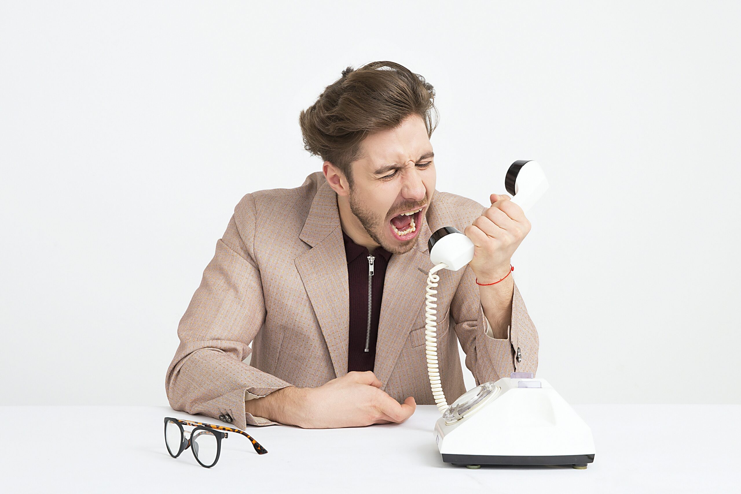 Man who doesn't know how to communicate with his angry spouse screaming into the phone.