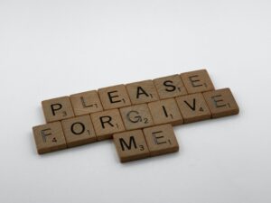 Scrabble tiles that read "Please forgive me."