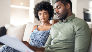 Couple sitting on a couch discussing calmly discussing finances without communication issues.