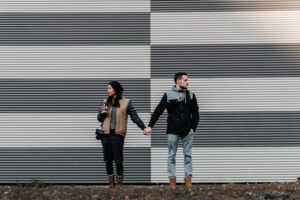 Couple with a lack of self-awareness in their relationship, holds hands while looking in away from one another.