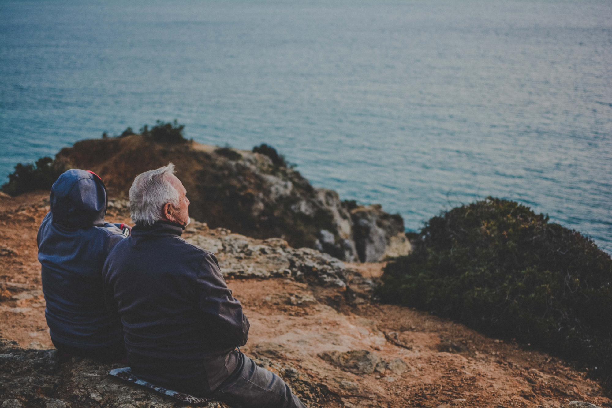 unhappy marriage at 60 Couple sitting by the ocean contemplating their marriage now that they're in their 60s.