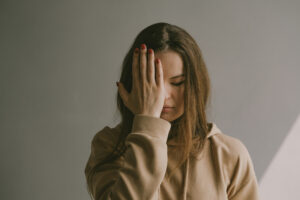 Woman holding her head in frustration wondering why her husband isn't fighting for their marriage.