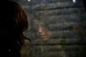 Woman staring out a window contemplating how to forgive infidelity.