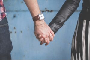 Close up of a man and woman holding hands whoa re determined not to have a boring sex life in their long term marriage.