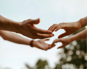 Close up of the hands of a married couple reaching out to each other as they figure out how to bring intimacy back in a marriage.