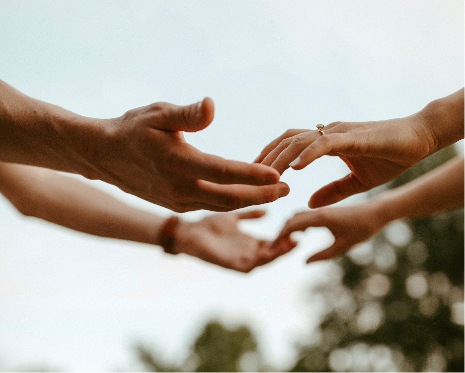 how-to-bring-intimacy-back-in-a-marriage Close up of the hands of a married couple reaching out to each other as they figure out how to bring intimacy back in a marriage.